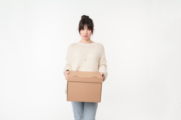 Sad and upset woman holding cardboard with online order and copy space for handwriting mockup. Moving day concept. Lay out home stuff for it's place. Return package to sender.