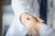 Closeup image of healthcare professional or doctor or dentist shaking hands with patient.