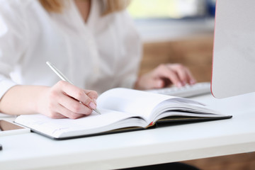 Female hand holding silver pen ready to make