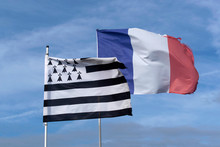 French And Breton Flags Fly In A Blue Sky