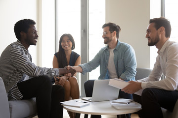 Wall Mural - Multiethnic staff meet client boss shake hands express respect