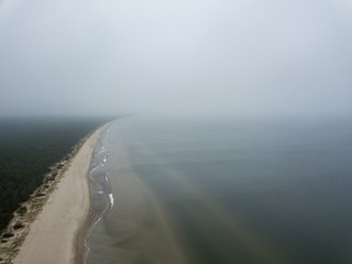 Wall Mural - seaside beach with water covered in fog mist