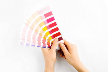 Female hand holding color swatches. Color trend palette. Flat lay, top view.