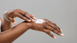 © Prostock-studio - Black woman applying body lotion to her hands