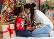 © Prostock-studio - Loving black mother giving Christmas present to her little daughter