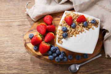 Wall Mural - bowl of yogurt with granola and fresh berries, top view