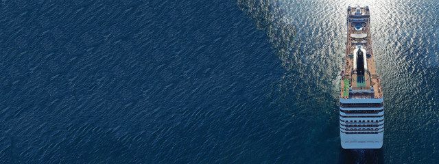 Aerial drone panoramic photo of huge cruise liner ship with top deck swimming pool cruising open ocean sea