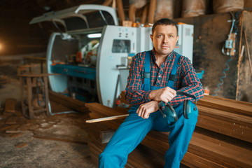 Joiner in uniform at his workplace on timber mill