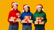 © Prostock-studio - Three Diverse Girls Holding Xmas Gifts Standing, Yellow Background, Panorama