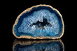 Geode with crystals of blue color. Quartz geode with transparent crystals on a black mirror background..