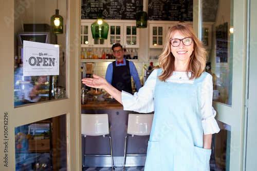 Fotografía Small business owner woman standing in cafe door and smiling
