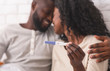 © Prostock-studio - Happy afro couple holding pregnancy test with positive result