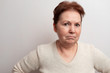 © Yura - Old woman on a white background in a light sweater. Emotions