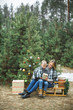© sofiko14 - Mother and son in gray knitted sweaters enjoying beautiful winter day outdoors, while sitting on wooden sledge decorated with nice Christmas Santa presents. Decorated Christmas tree