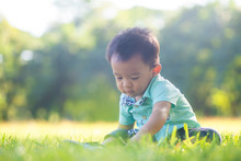 Adorable Smart Baby Boy Playing In City Green Park