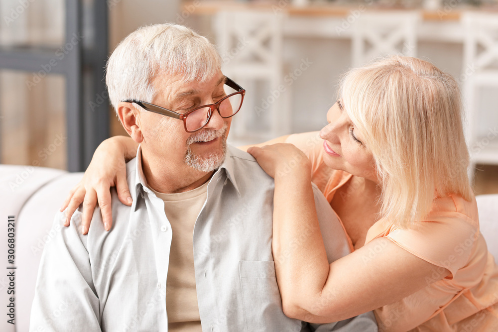 Happy mature couple resting together at home