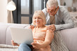 © Pixel-Shot - Mature couple with laptop resting at home