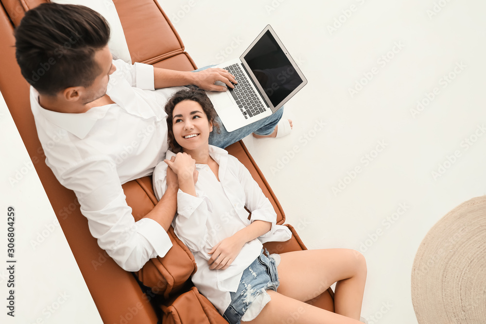 Happy young couple with laptop at home