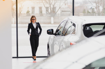 Wall Mural - business woman in auto salon. concept of female driver