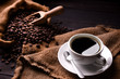 © amenic181 - Cup of coffee and coffee beans in burlap sack on old wooden background