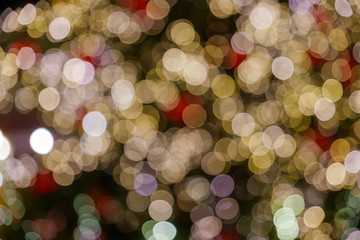 Wall Mural - Gold and red Christmas light shiny abstract round bokeh on black background. Colourful Glitter bokeh from blurry decoration bulbs.