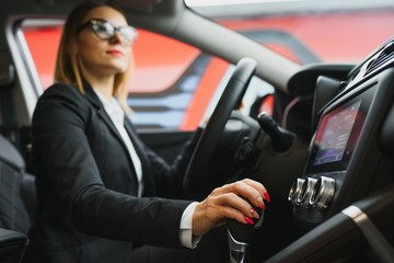 Wall Mural - Young business woman driving in her car to work. Successful business concept. business woman driving