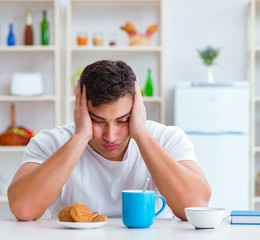 Wall Mural - Man falling asleep during his breakfast after overtime work