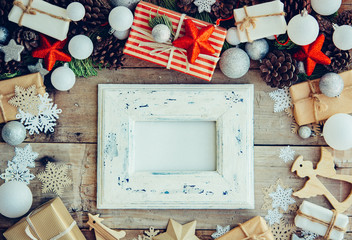 Wall Mural - Christmas background with frame and gift boxes on the wooden tab