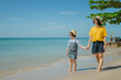 © Angkana - Summer Vacation and Happy Family Concept : Woman and child walking on sand beach and they felling happiness.