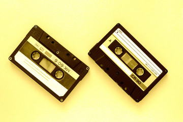 Two audio tape cassettes, top view. Old technology concept. Yellow color toned