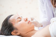 © nareekarn - Woman receiving facial acupuncture treatment