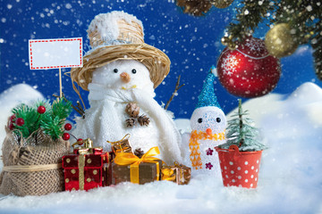 Snowman in a snowdrift with gifts for Christmas and New year