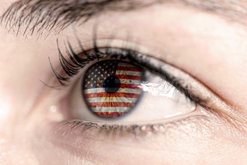 Flag of USA reflects in woman green eye - close-up view - election, sport, hope, young, generation	