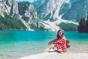 Wall Mural - woman sitting on the beach of mountain lake summer season