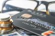© hqrloveq - Stacked COINS and bank CARDS and credit CARDS are placed on the spread of dollars