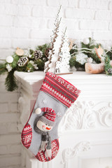 Beautiful Christmas sock with gifts on the fireplace