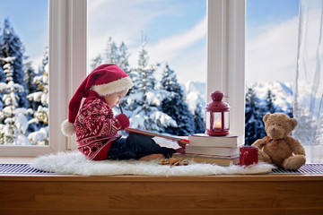 Sticker - Sweet blonde child, boy, sitting on window shield with teddy bear friend toy, writing letter to Santa Claus and reading book