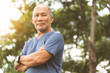 © eggeeggjiew - Asian Senior man in blue shirt smiling with arms crossed before exercising.