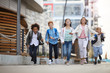 © AnnaStills - Group of multiethnic school children running together along the street after school