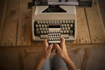 Wall Mural - Concept of write and work  with old and modern new technlology - typwriter and modern cellular mobile phone taking picture at the keyboard with letters - woman hands worker people