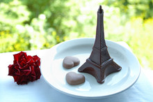 Chocolate Dessert On A Plate The Eiffel Tower And Two Hearts And A Red Flower. Outdoors.