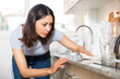 © JackF - Young woman housewife cleaning furniture at  kitchen at home