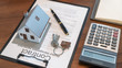 © PIC SNIPE - Desk of real estate agent with house model, key, pen on contract document and calculator for contract to buy, get insurance or loan real estate or property.
