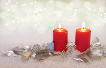 two burning candles with silvery eucalyptus leaves, copy space