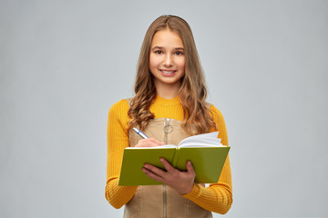 Sticker - high school, education and vision concept - smiling teenage student girl with notebook or diary over grey background