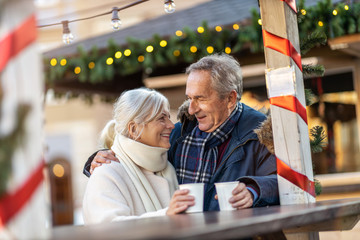 Wall Mural - Happy senior couple having fun on the Christmas Market