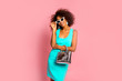 canvas print picture - Beautiful african american young girl smiling and posing in stylish dress, trendy purse bag and white sunglasses at pink background in studio.Young black woman with afro hairstyle smiling. 