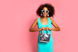 © ClaudiK - Fashionable young beautiful african american woman with afro hairstyle posing in elegant turquoise dress. Pink room.Beautiful african american young girl smiling and posing in stylish dress.Copy space