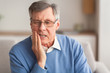 © Prostock-studio - Elderly Man Having Toothache Sitting On Sofa At Home