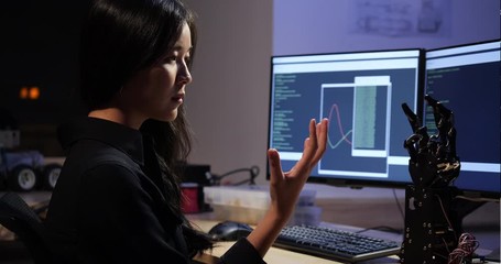 Asian teenage engineer assembling and testing robotics arm responses in laboratory. Student engineer programming controller circuit synchronize technology and collaborating development robot.